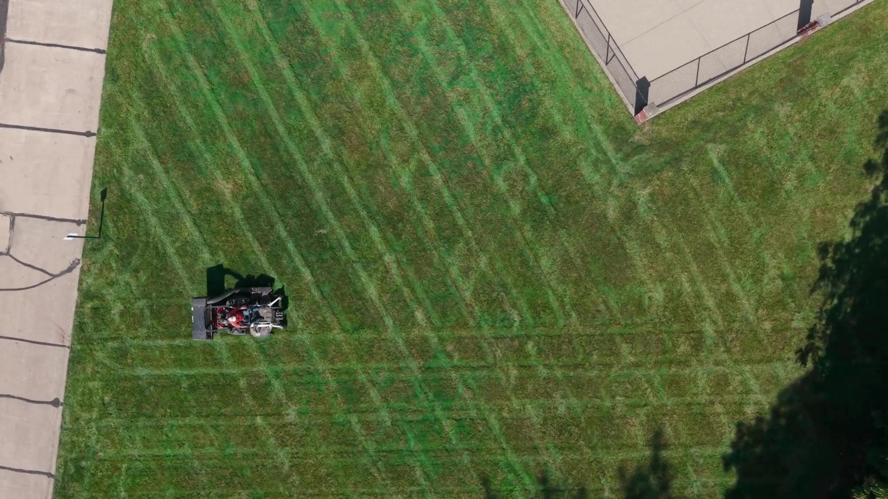 Aerial view of an Exscape Group mower striping a large lawn