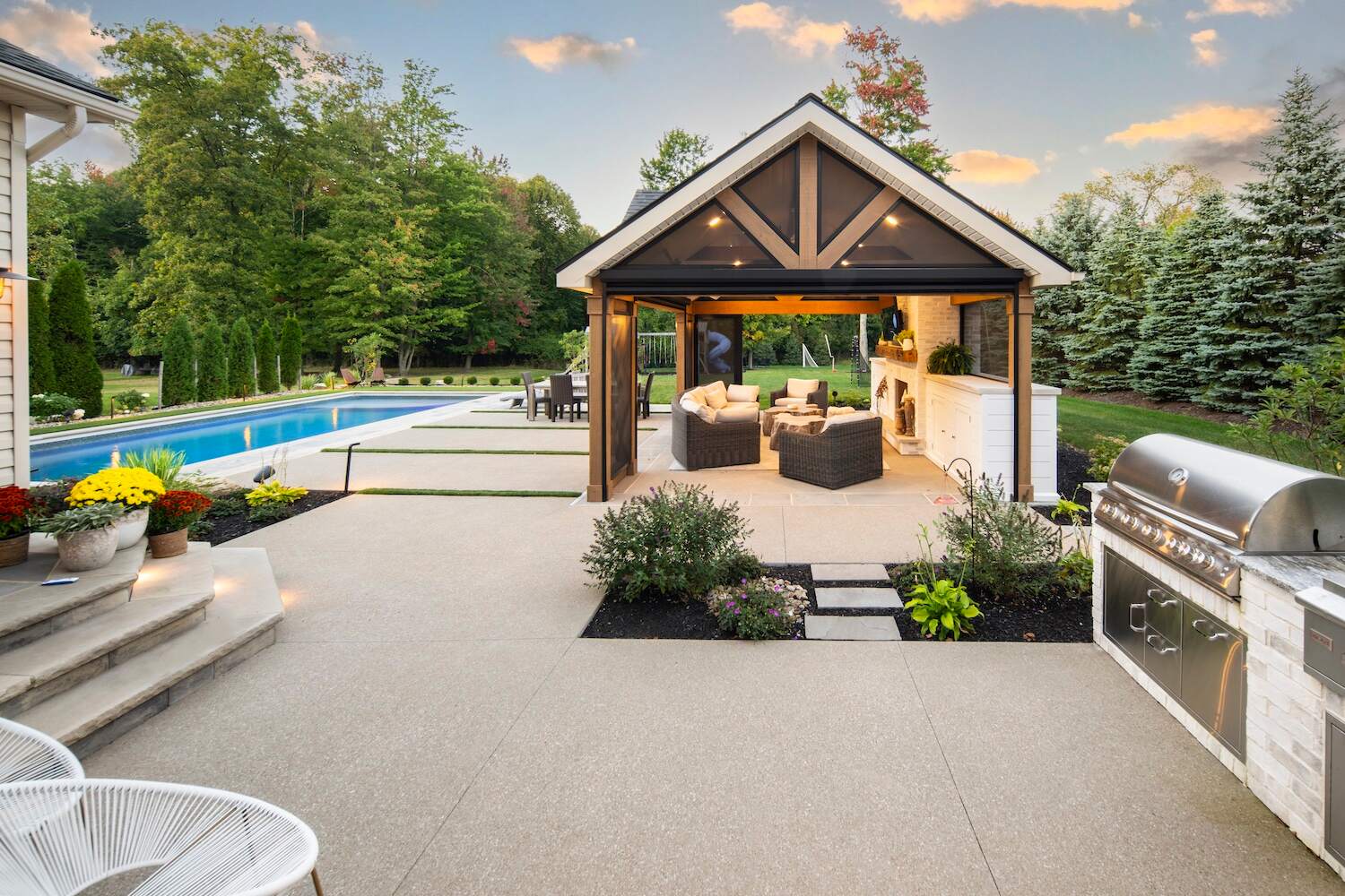 Backyard pool with outdoor pavilion, fireplace, and grill island in Painesville, OH
