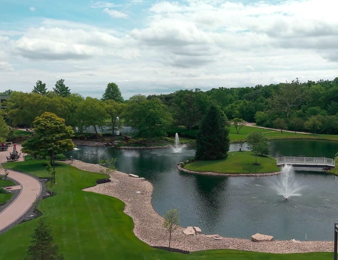 Campus pond with fountains and walking path maintained by Exscape Group