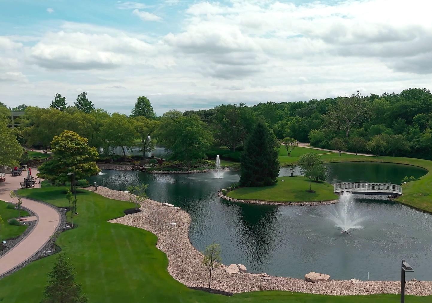Campus pond with fountains and walking path maintained by Exscape Group