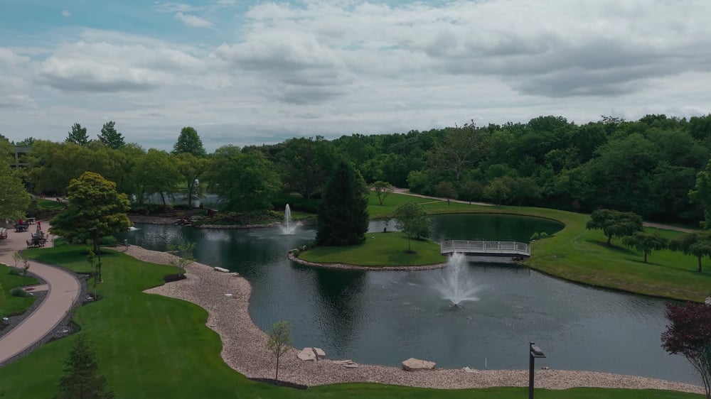 Campus pond with fountains and walking path maintained by Exscape Group