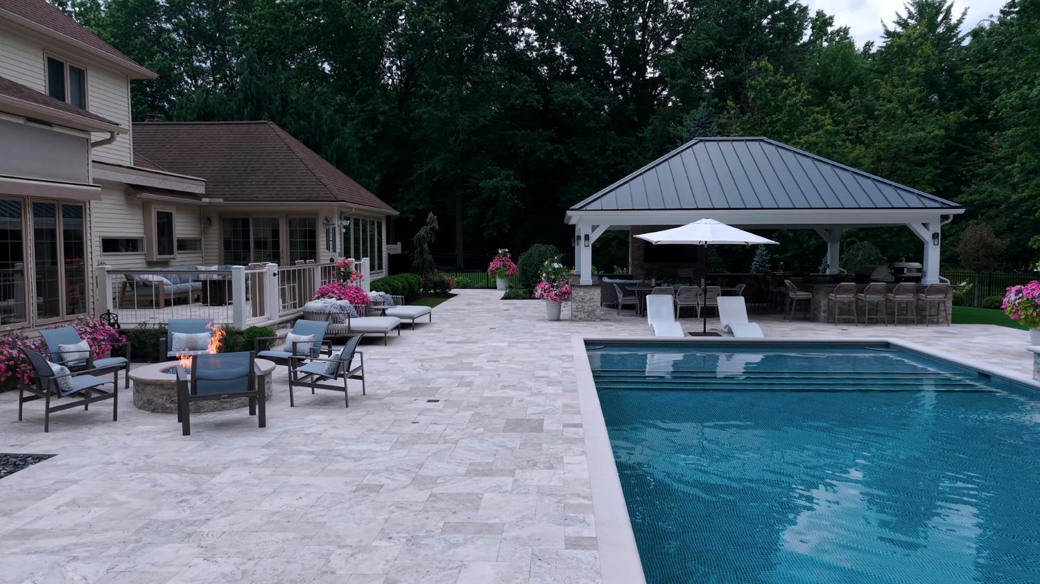 Natural stone pool deck with pavilion and poolside seating