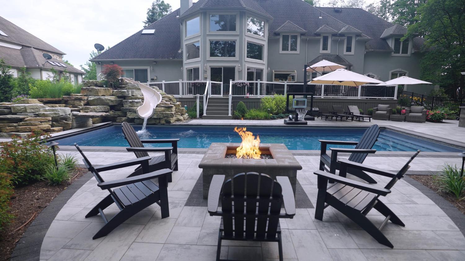 Paver pool deck with fire pit and Adirondack chairs
