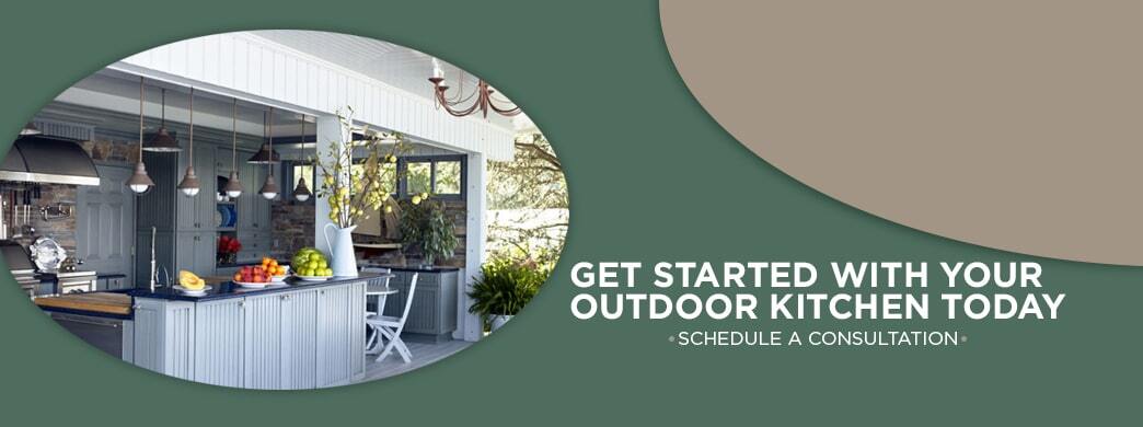 A daytime shot of a kitchen under the overhang of a house with bright fruit bowls and tidy arrangements, all cropped in an oval with text to the right reading "Get Started With Your Outdoor Kitchen Today. Schedule a consultation."