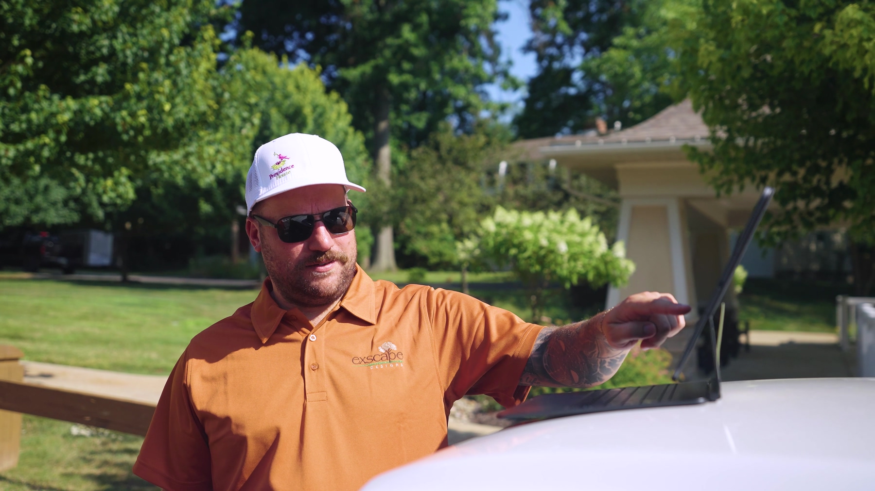 Exscape Group crew leader pointing out details on a tablet at a client property