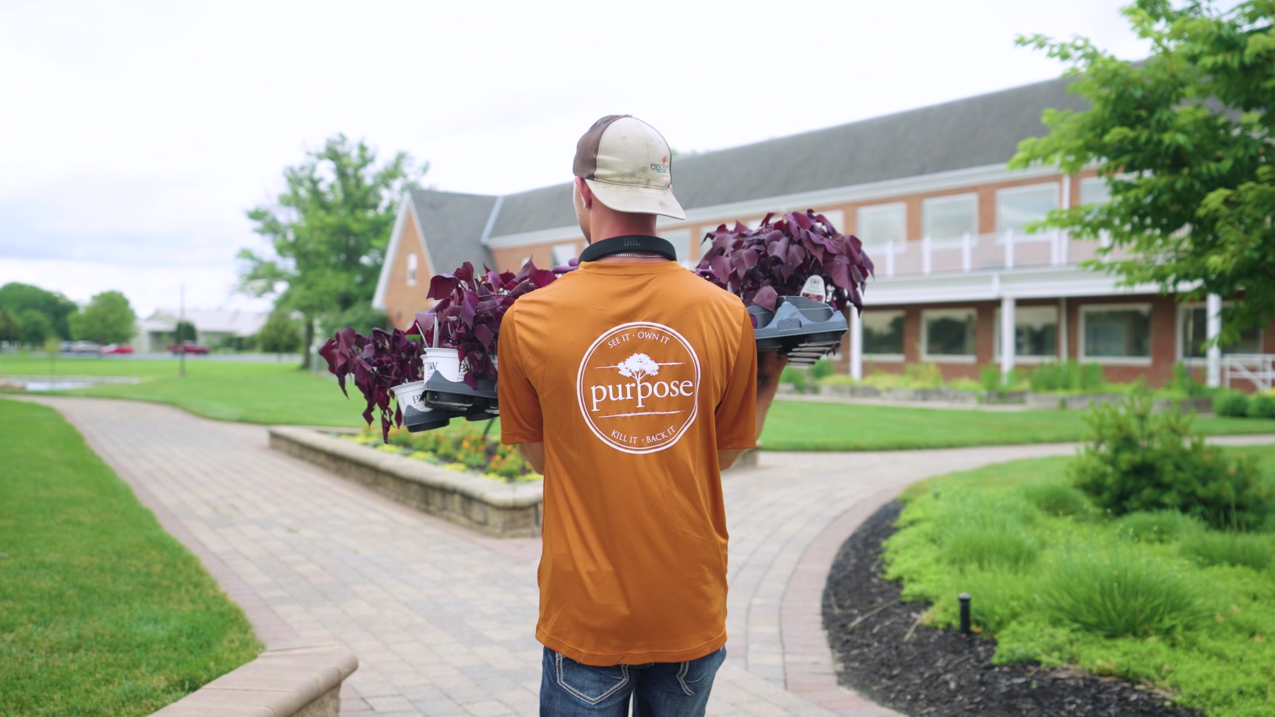 Exscape Group crew member carrying flowering plants for a seasonal color rotation