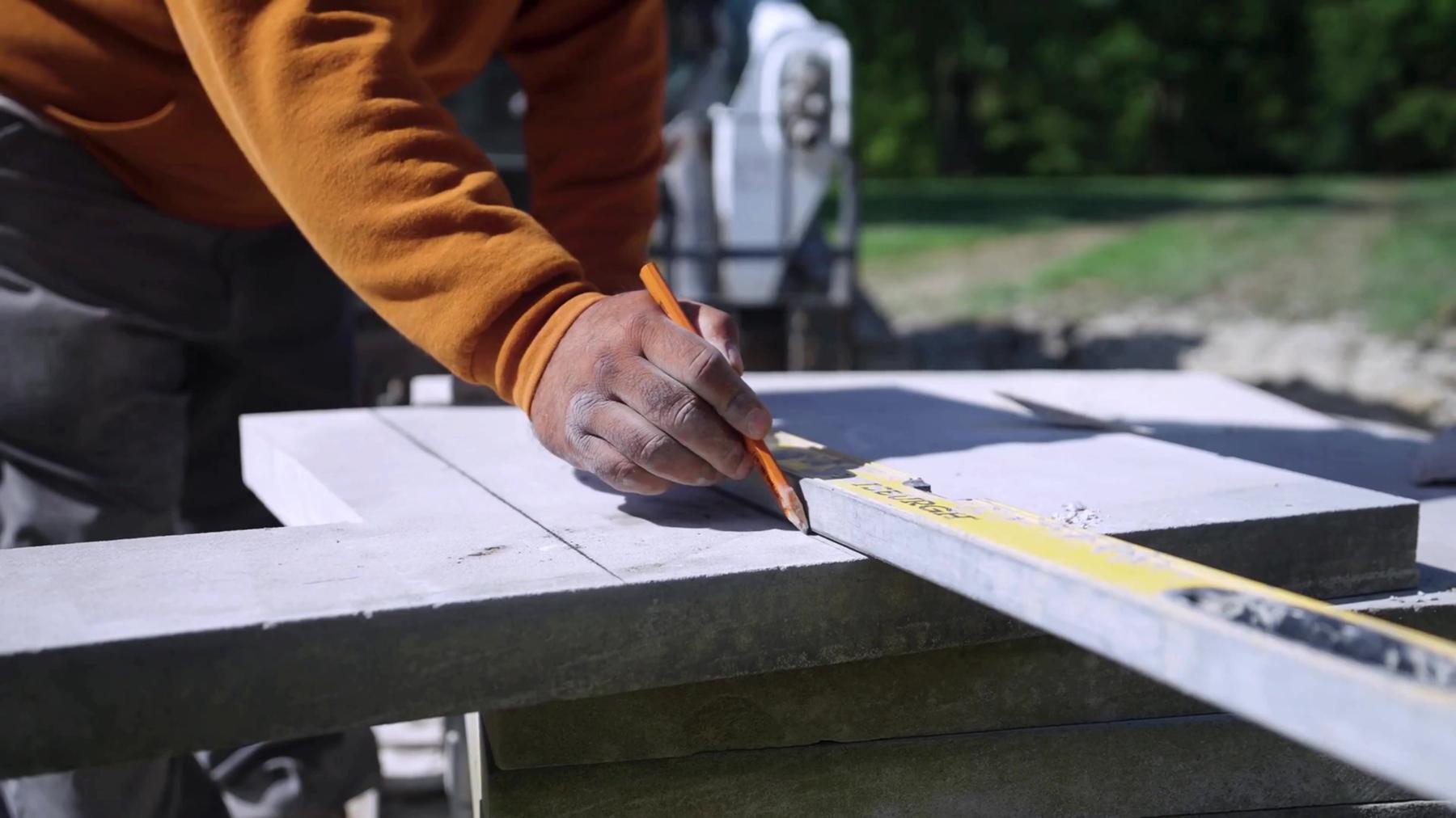 Exscape Group crew member marking a stone slab for a cut