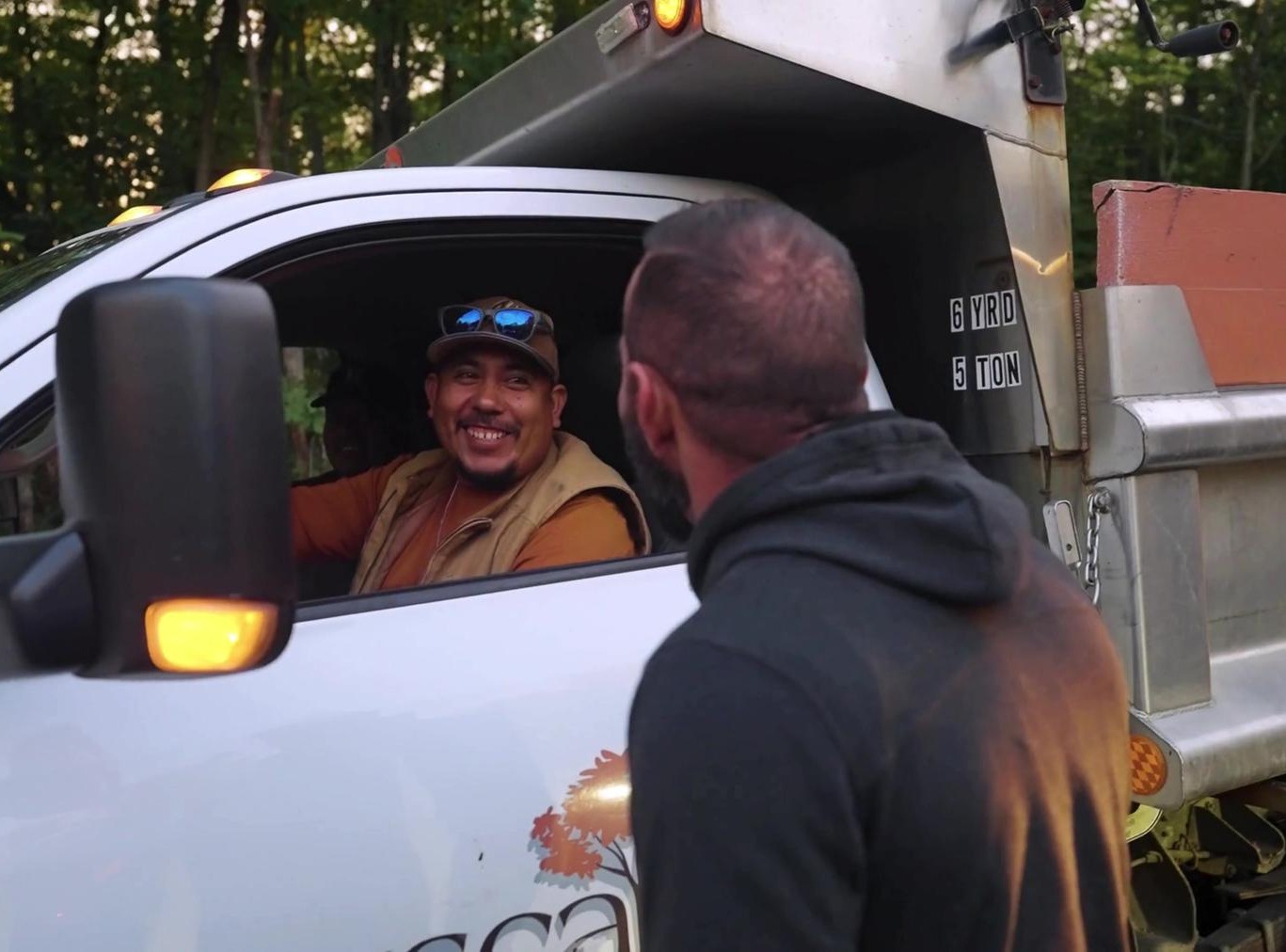 Exscape Group leader chatting with a crew member in a dump truck