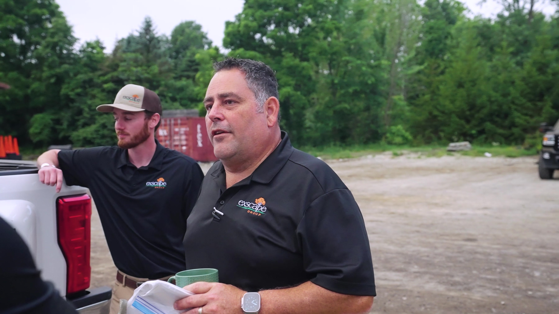 Exscape Group managers talking beside a pickup in the equipment yard