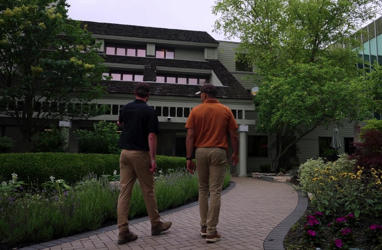 Exscape Group team members walking a paver path through landscaped gardens Exscape Group team members walking a paver path through landscaped gardens