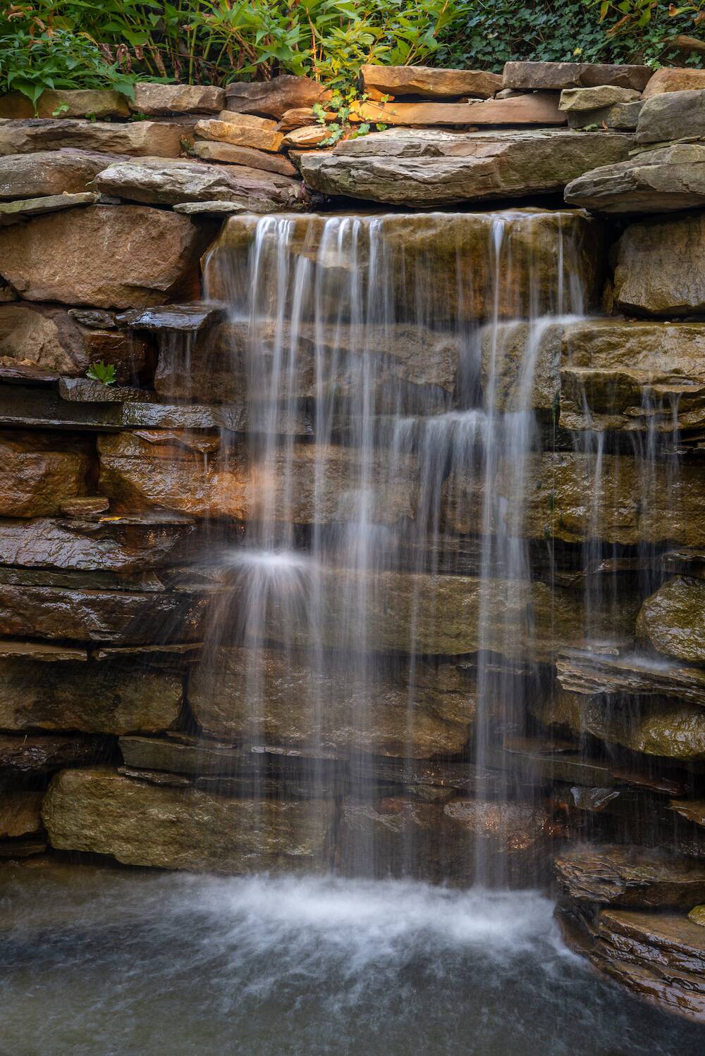 Natural stone waterfall water feature by Exscape Group in Moreland Hills, OH