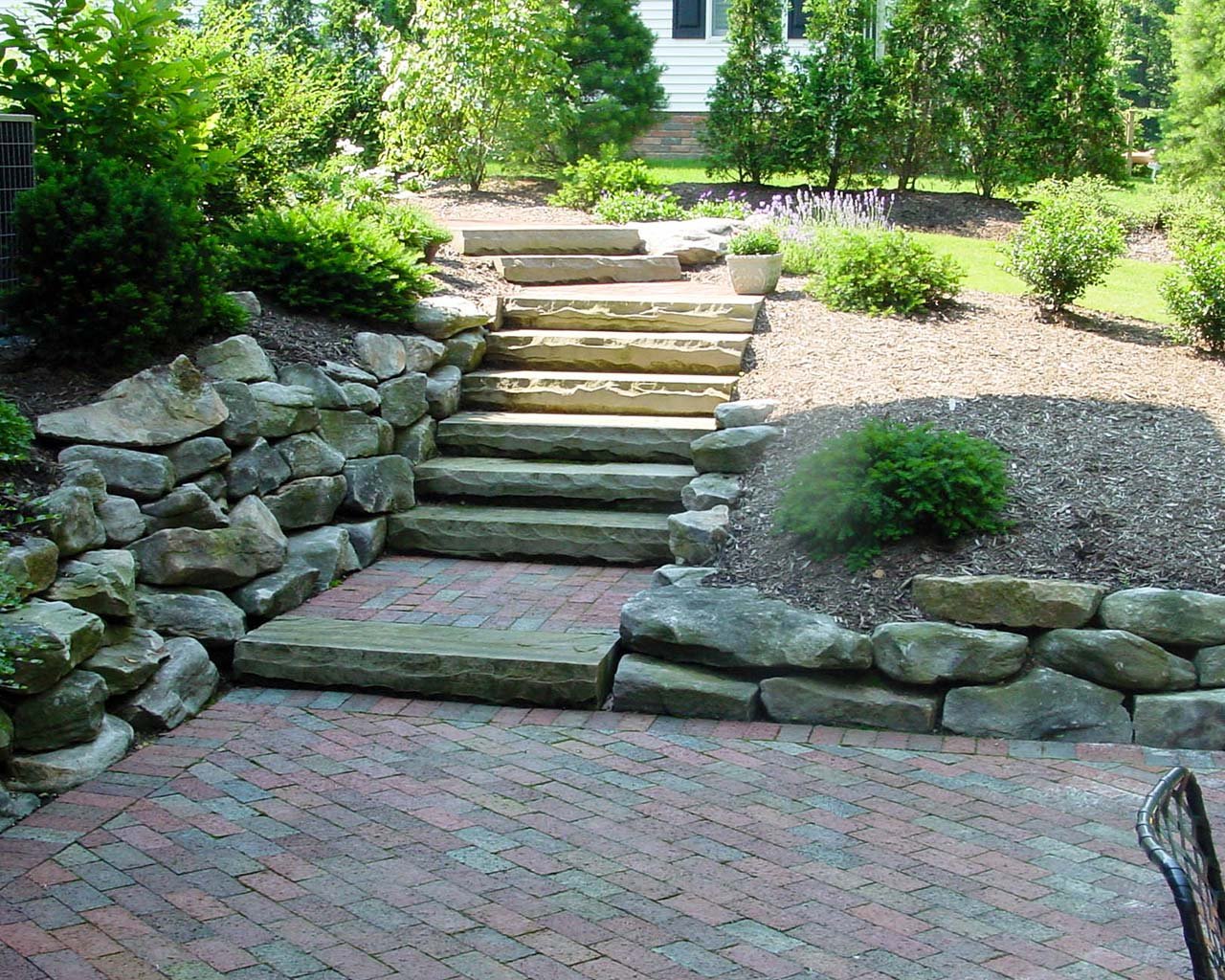 Stone retaining walls and steps on a sloped yard Stone retaining walls and steps on a sloped yard