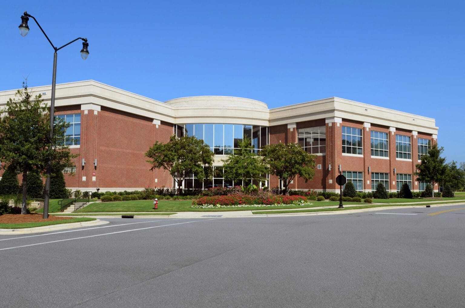 Maintained lawn and plantings outside a brick campus building