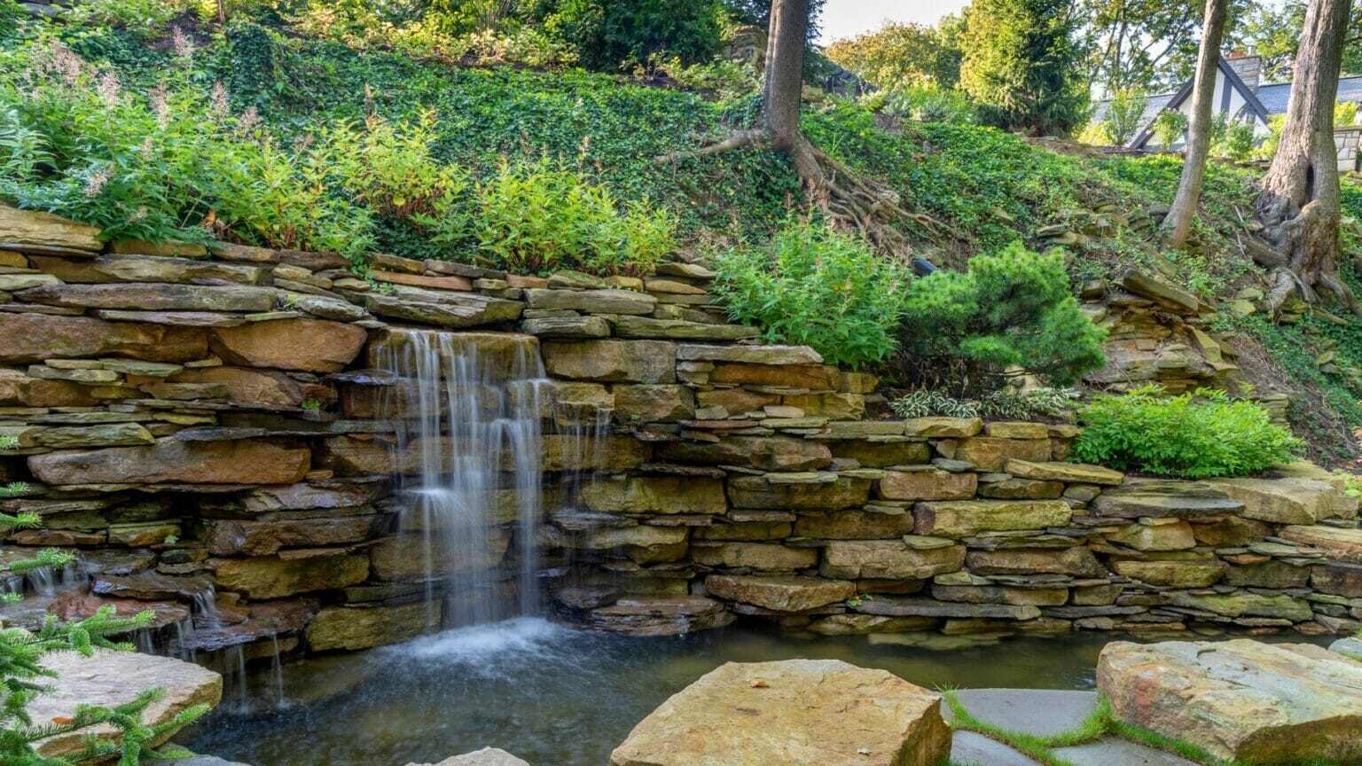 Stone wall water feature with plantings