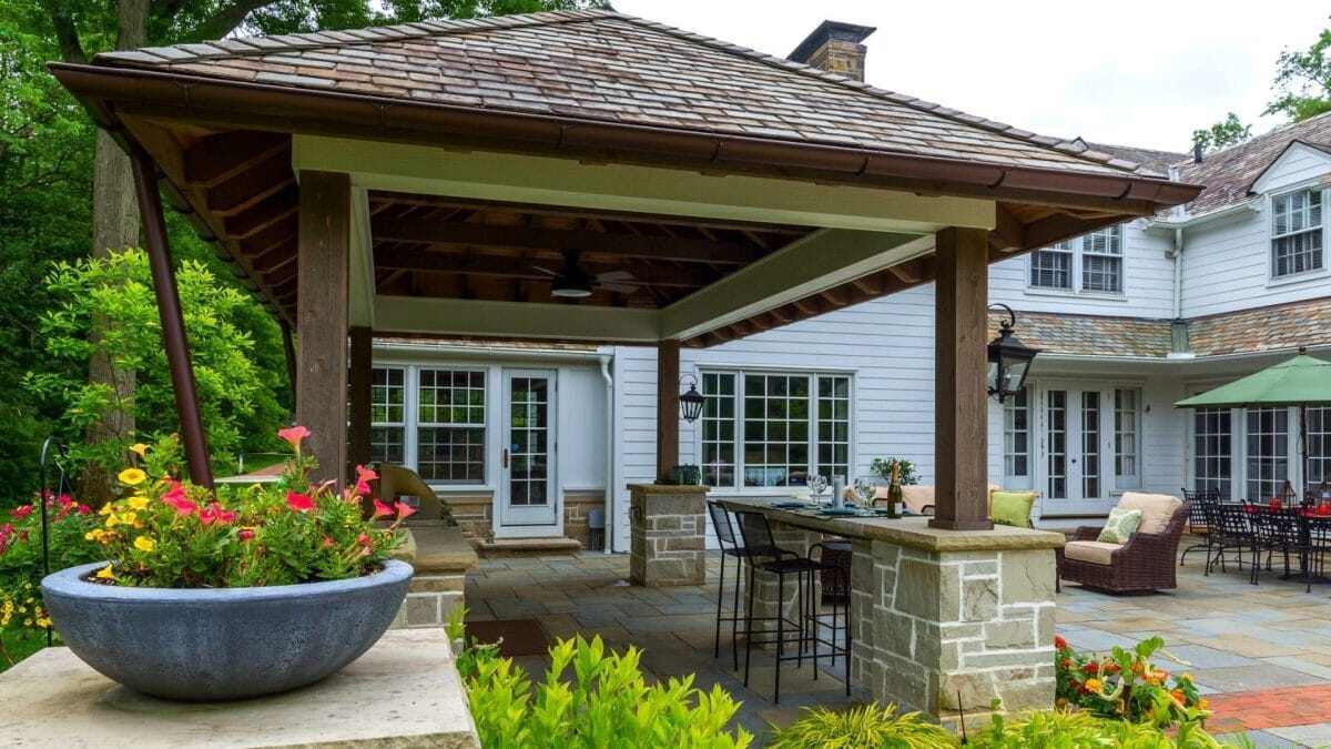 Timber pavilion with stone columns over an outdoor kitchen