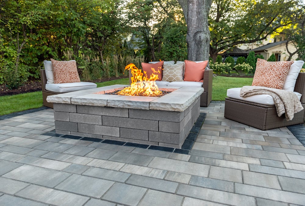 Paver patio with a stone fire pit and outdoor seating