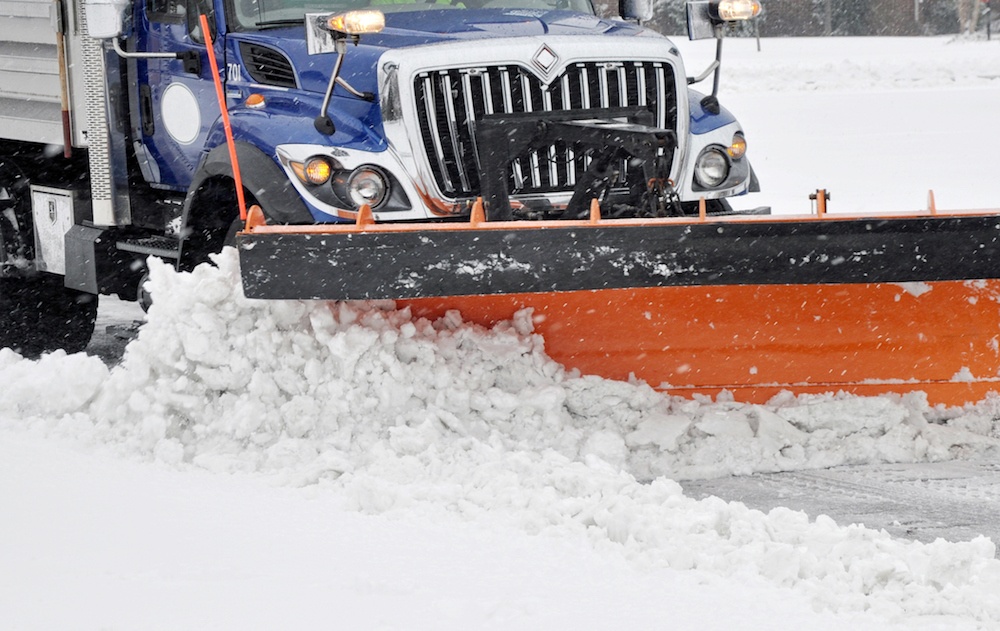 Snow plow clearing a commercial parking lot