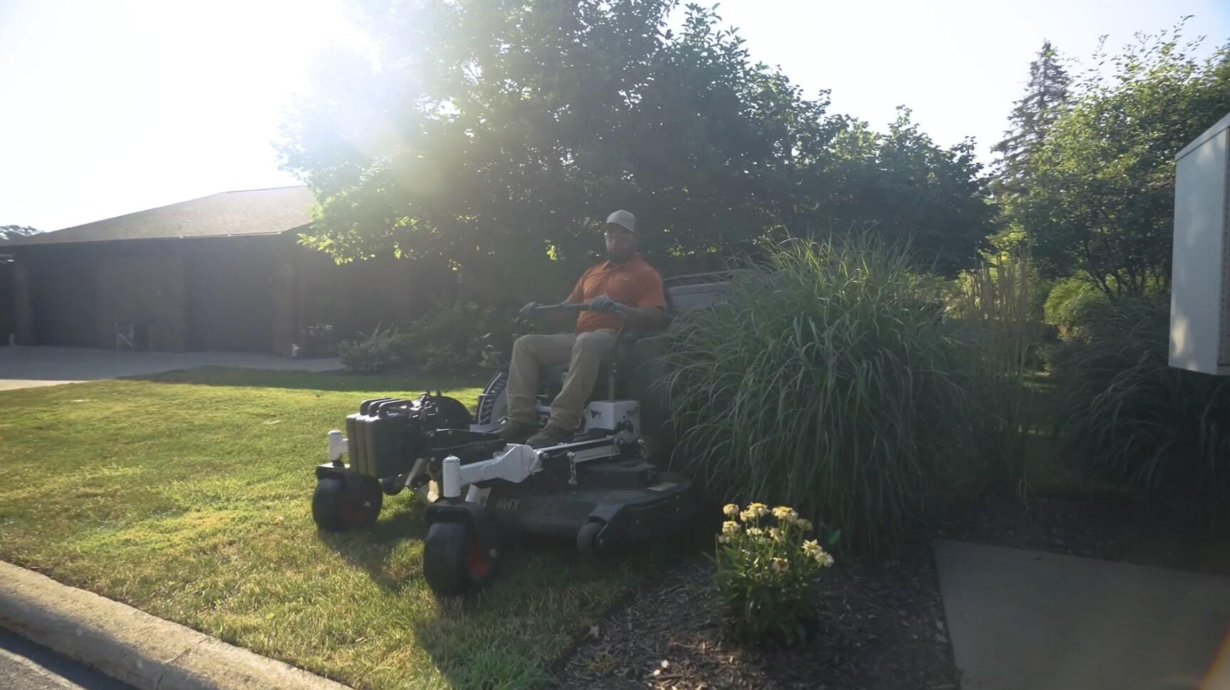 Landscape crew member mowing lawn with commercial equipment in Cleveland OH