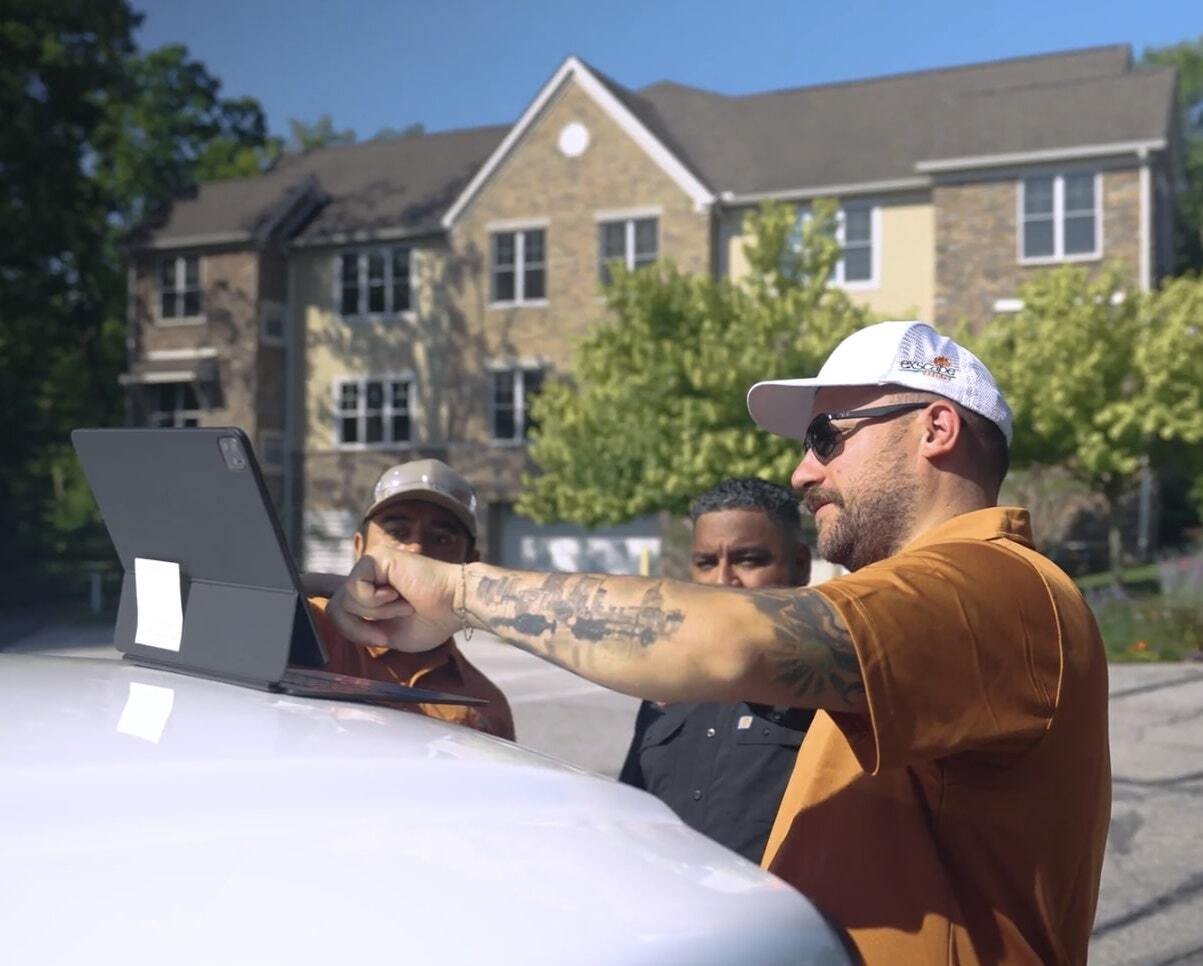 Landscape crew reviewing digital project plans on tablet in Moreland Hills OH