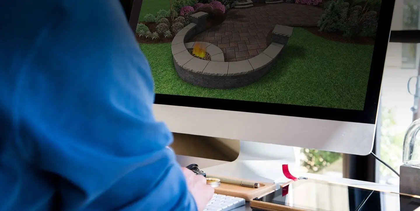 Landscape designer in Ohio creating 3D patio and fire pit design on computer for residential project