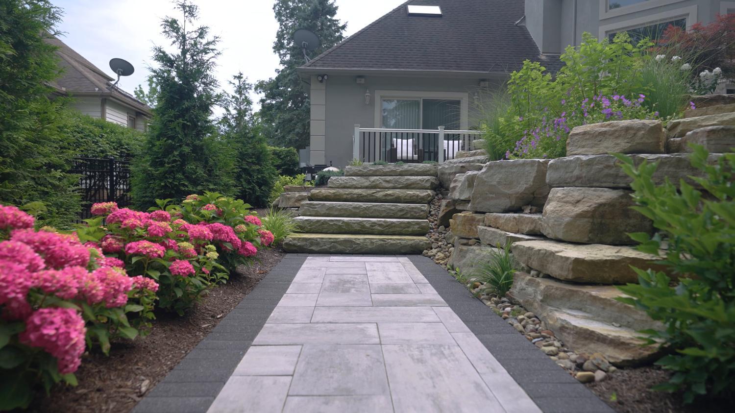 Natural stone walkway and steps with boulder walls and plantings