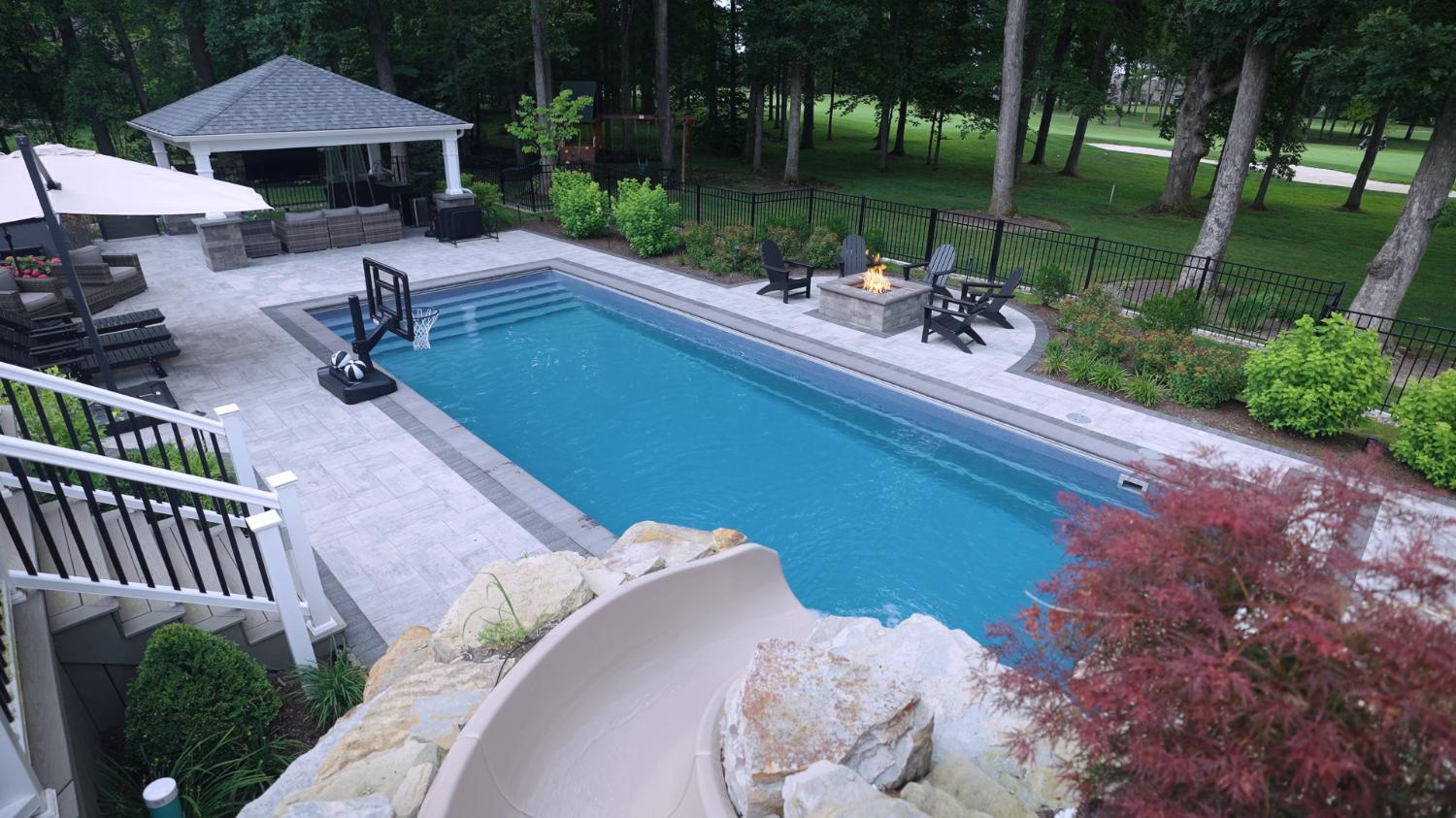 Inground pool with natural stone waterfall and landscaped hillside