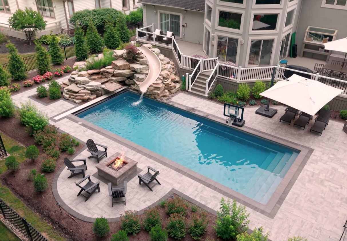 Private backyard pool retreat framed by trees and planting beds in Ohio