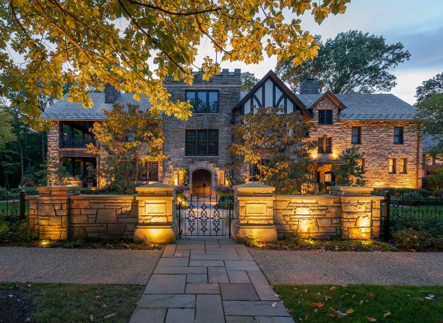Landscape and hardscape lighting on a stone entry wall and walkway by Exscape Group in Solon, OH