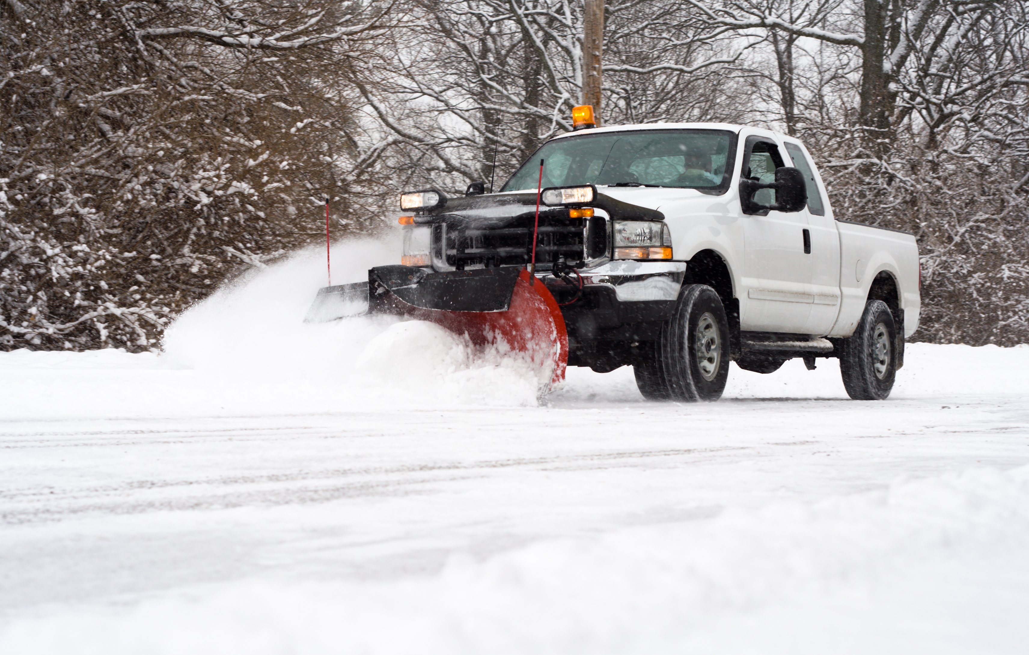 Commercial snow plow truck clearing a parking lot in Northeast Ohio