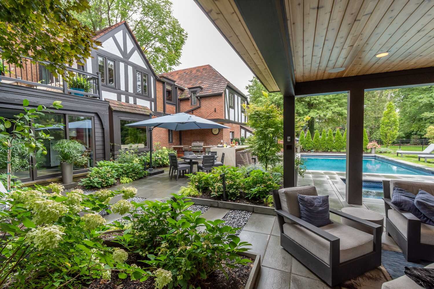Covered outdoor living area with lounge chairs overlooking a pool