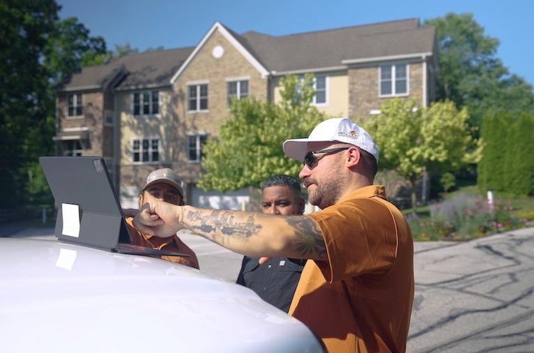 Landscape designer reviewing plans with homeowners outdoors