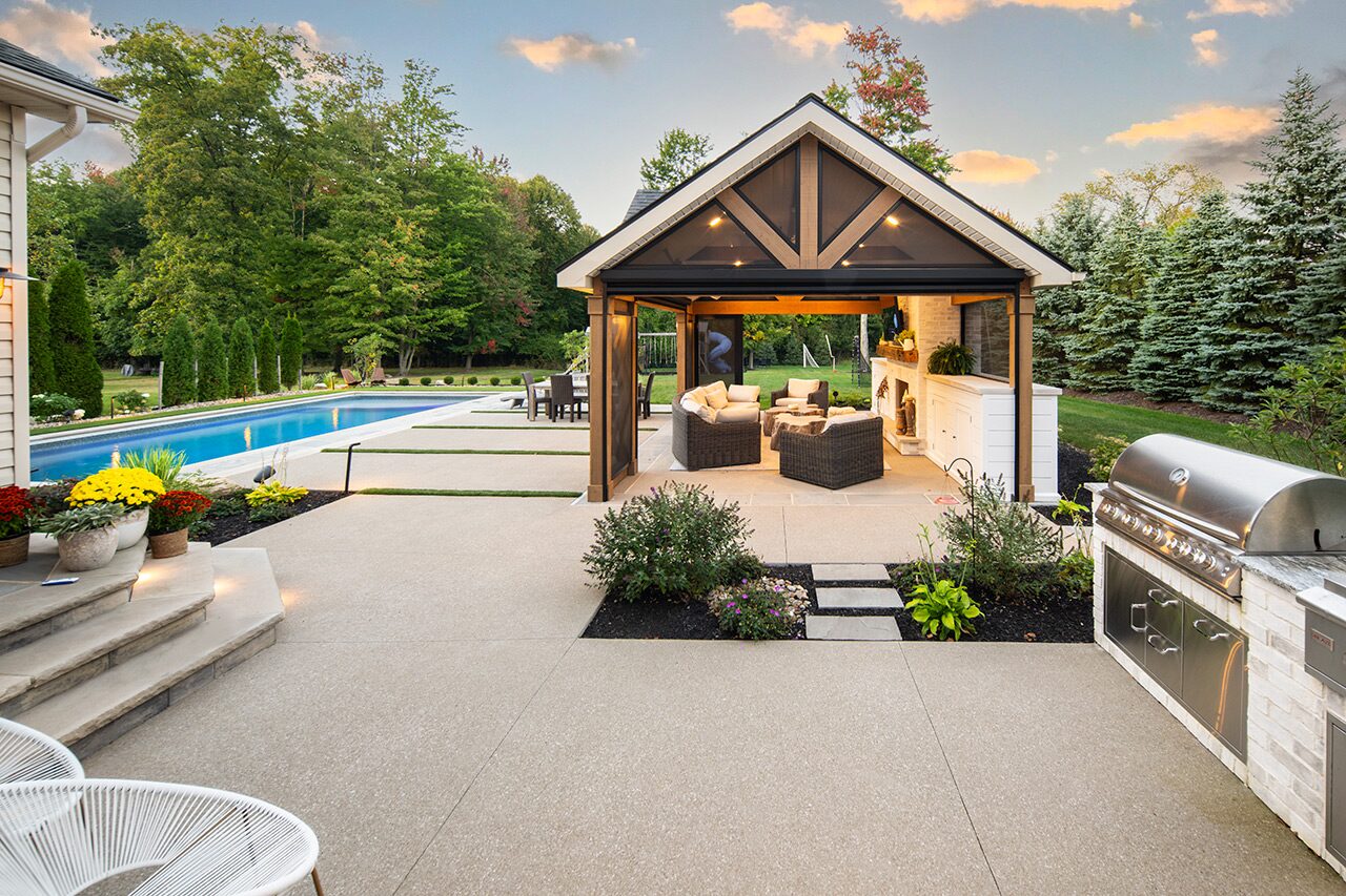 Backyard patio with pool, outdoor furniture, and warm evening lighting in Painesville, Ohio