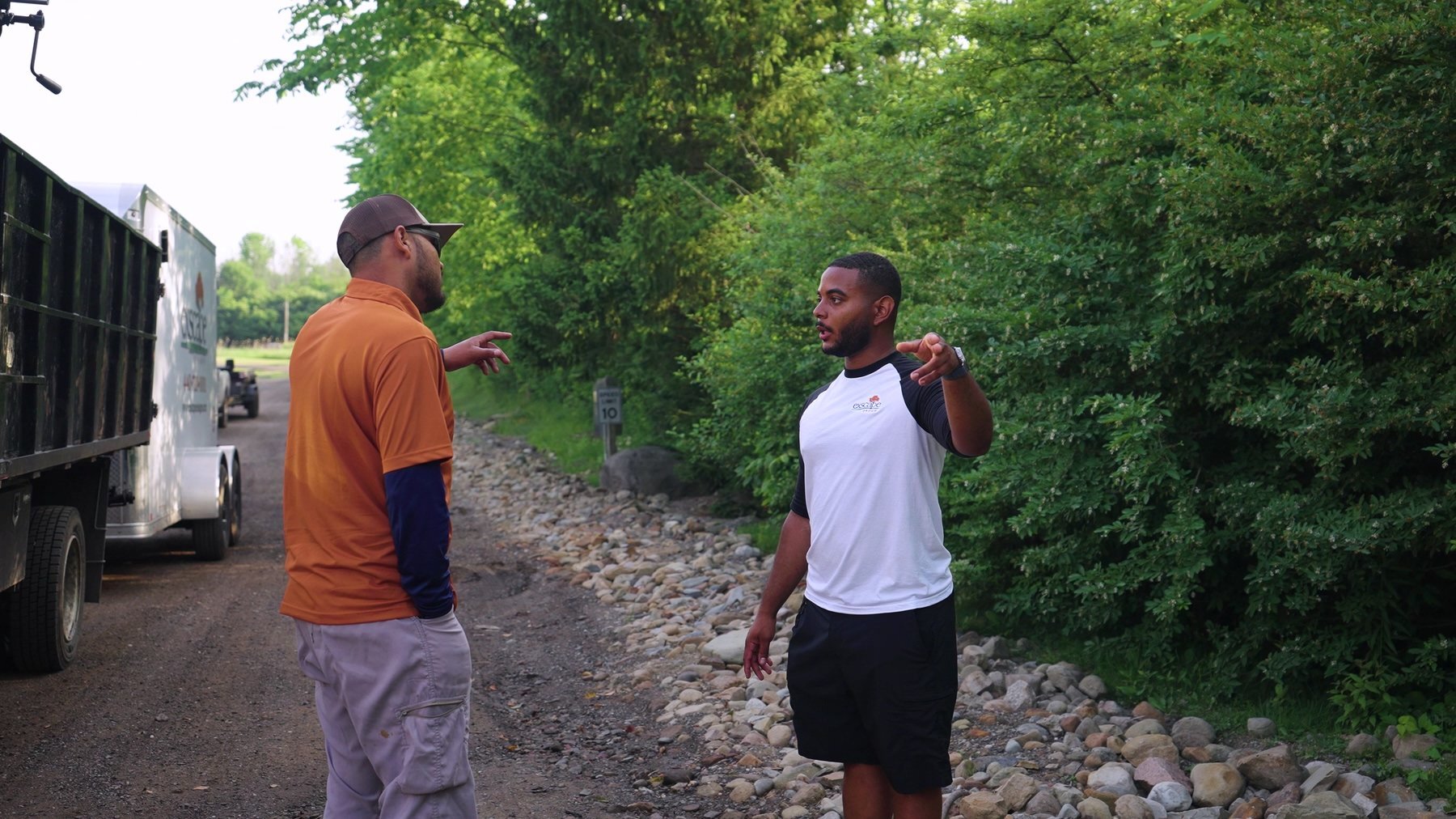 Exscape Group crew members talking beside a dump truck on a job site